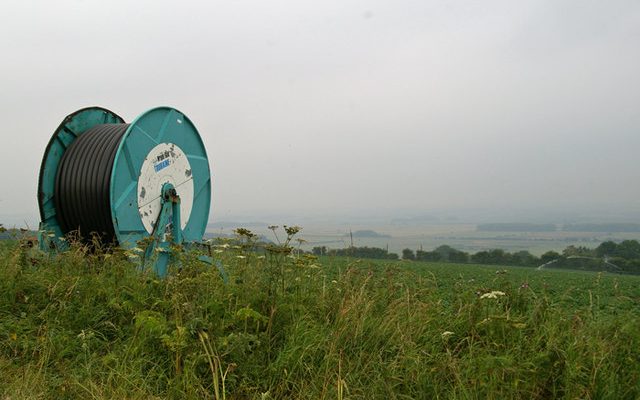 An irrigation hose reel at the edge of a potato field on the Lincolnshire Wolds in a dry summer