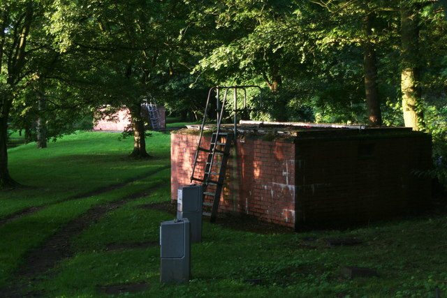 A brick borehole kiosk with an access ladder among trees at Hubbard's Hills, Louth
